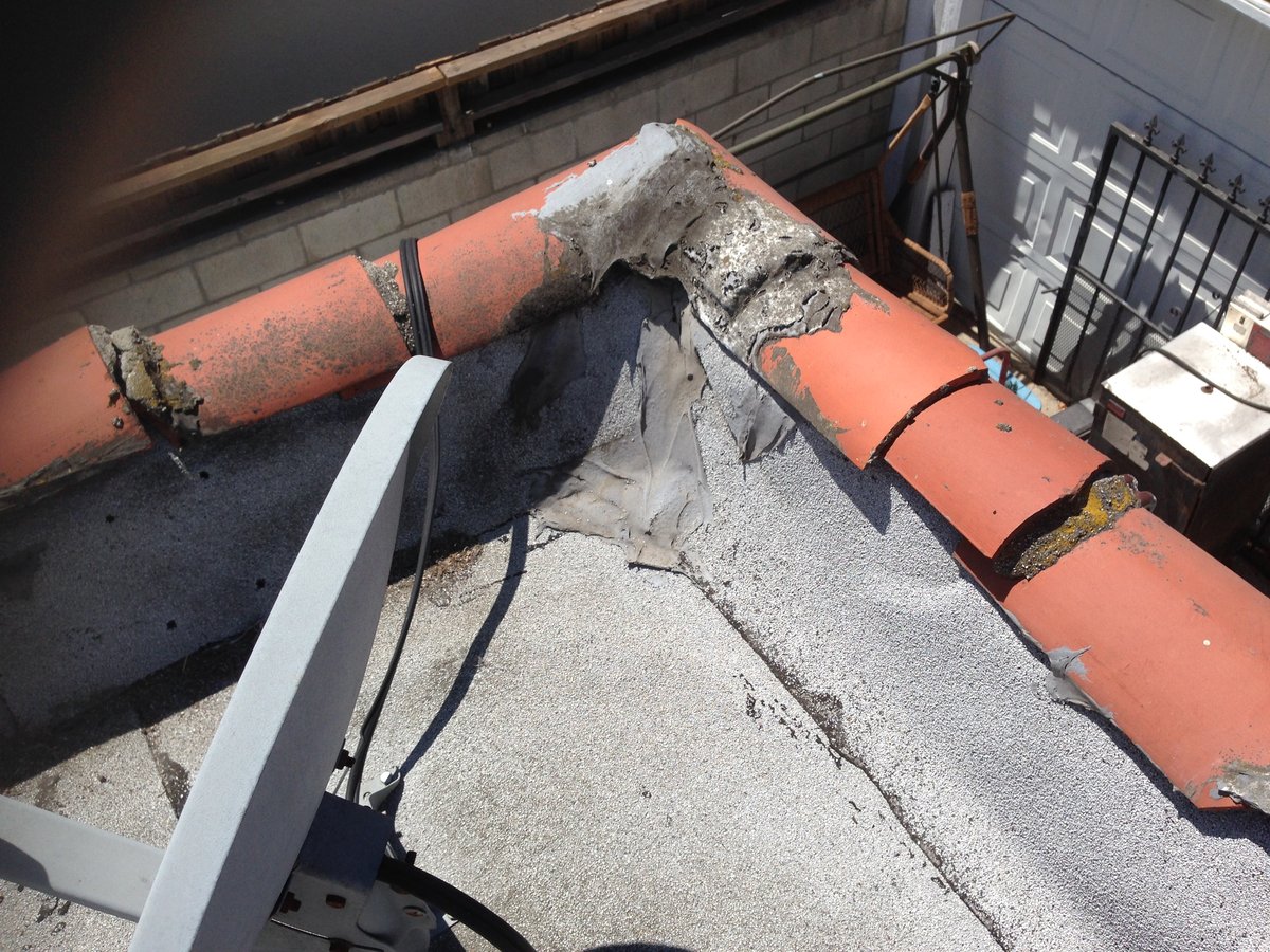 Clay tile cap running along the top of a flat-roof parapet wall, a tile-style coping.