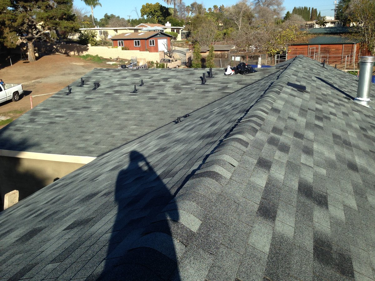 Ridge line where two slopes of a new asphalt shingle roof meet at the peak.