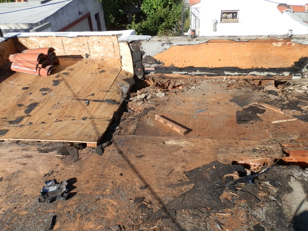 Old roofing stripped down to bare deck during a tear-off.
